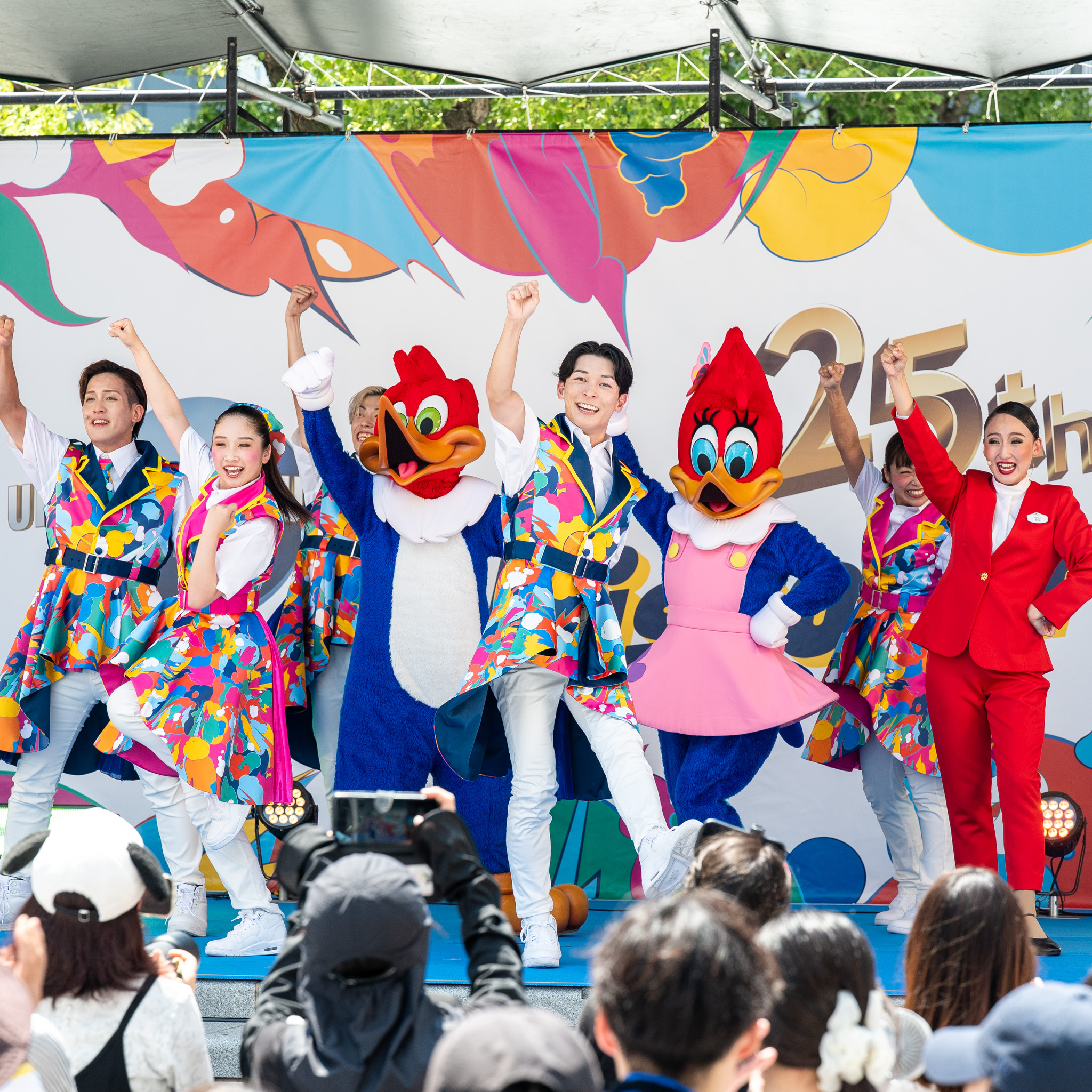 一斉に拳を突き上げる出演者とキャラクターたち