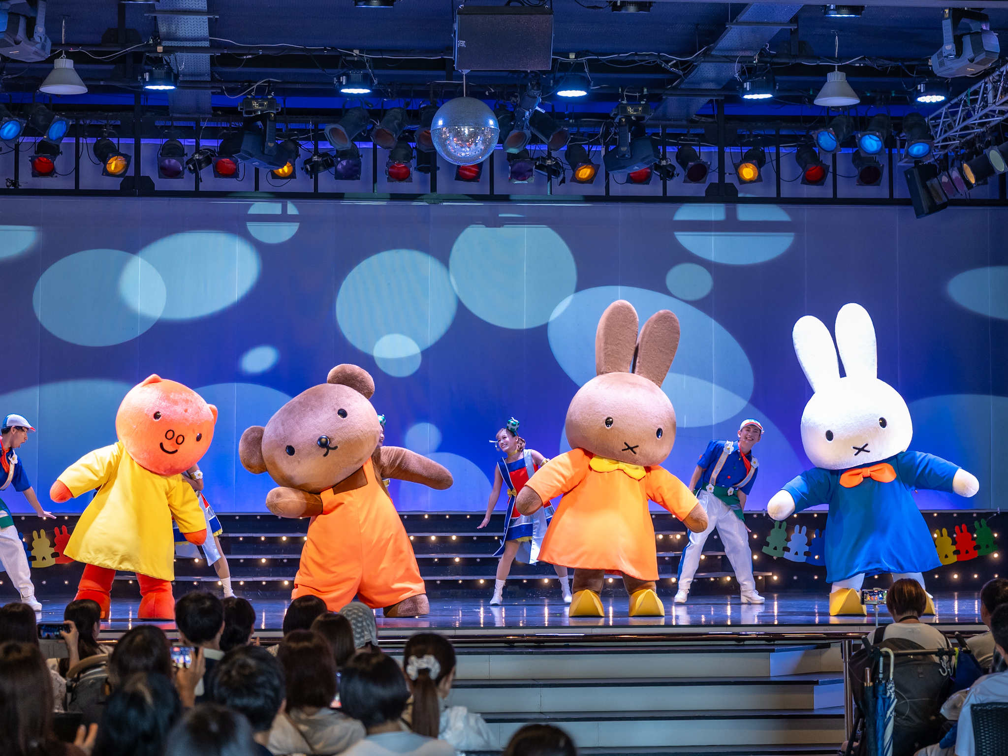 青い照明の下で踊るミッフィー、メラニー、ボリス、グランティ