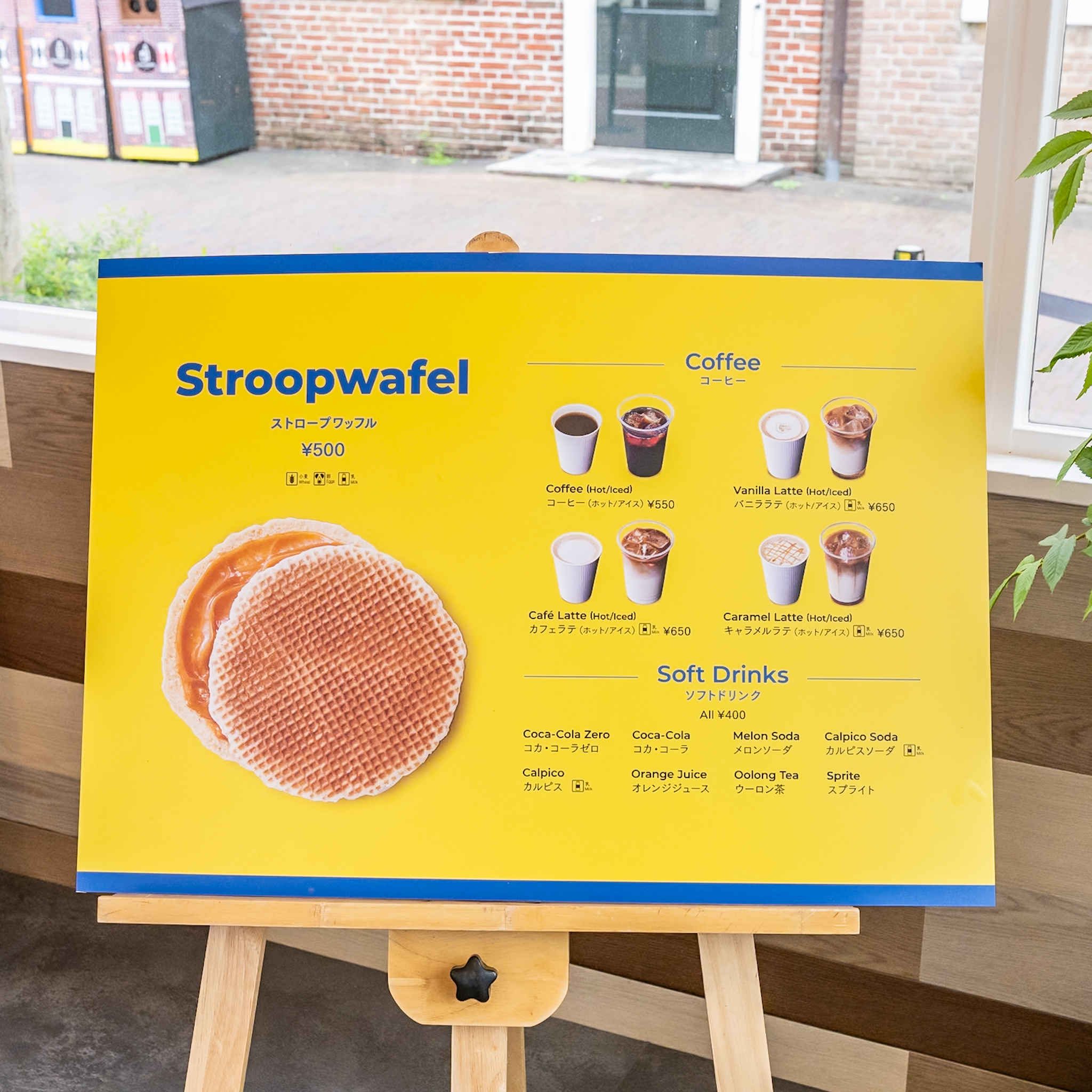 ストロープワッフルとコーヒー、ラテ、ソフトドリンクが並ぶ店内メニューボード