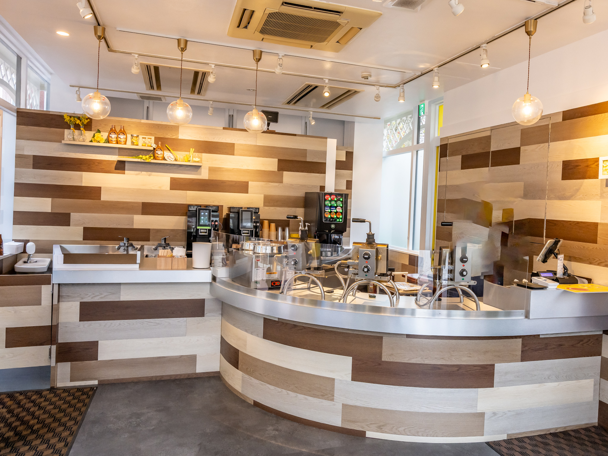 木目の壁と曲線カウンターにワッフル焼き機が並ぶ「STROOPWAFEL」の店内