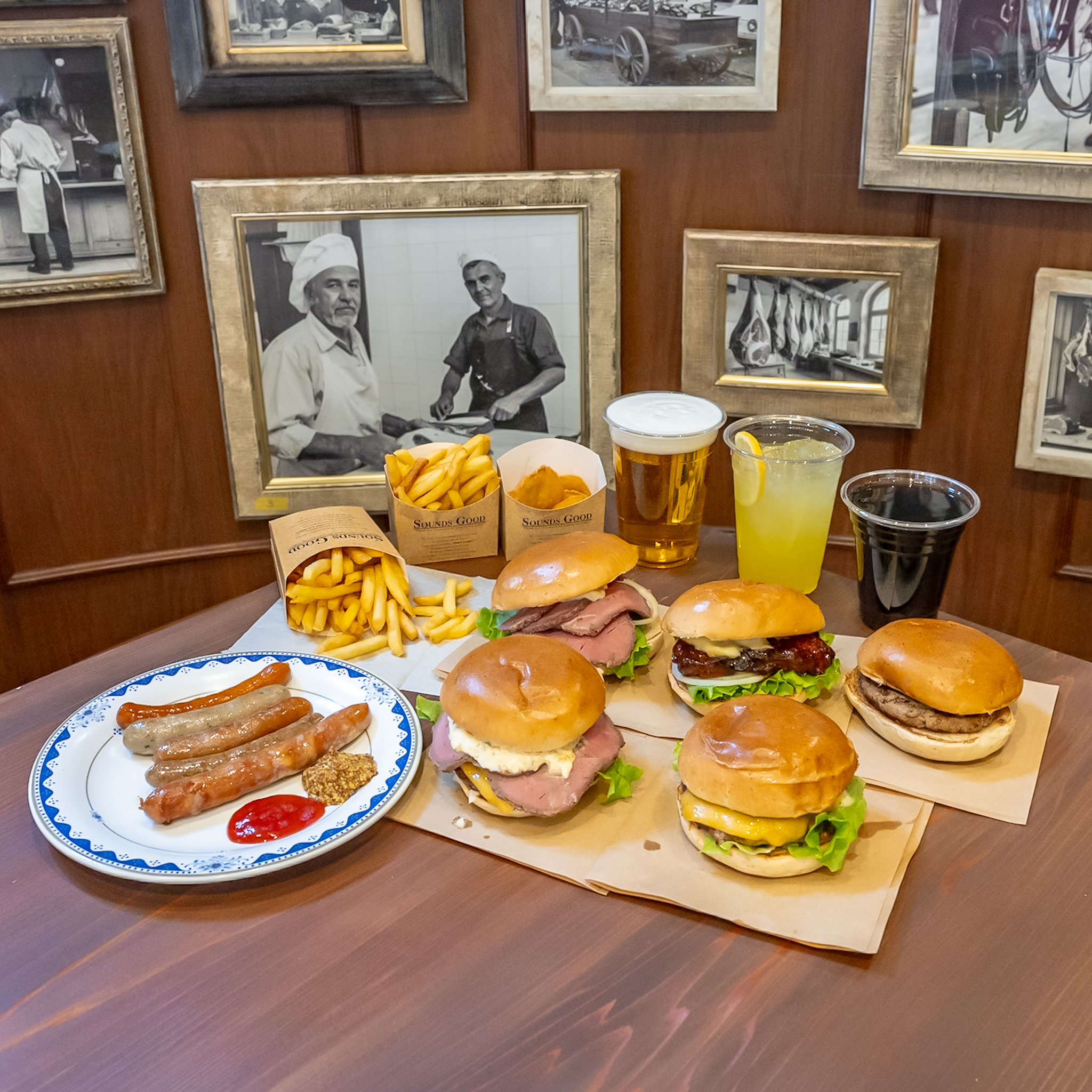精肉店の白黒写真が並ぶ壁とハンバーガーのテーブル