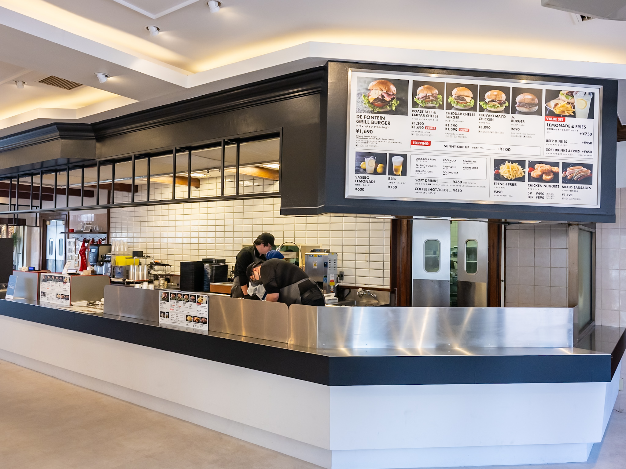 大きなメニューボードを掲げたデ フォンテイン グリルバーガーの注文カウンター