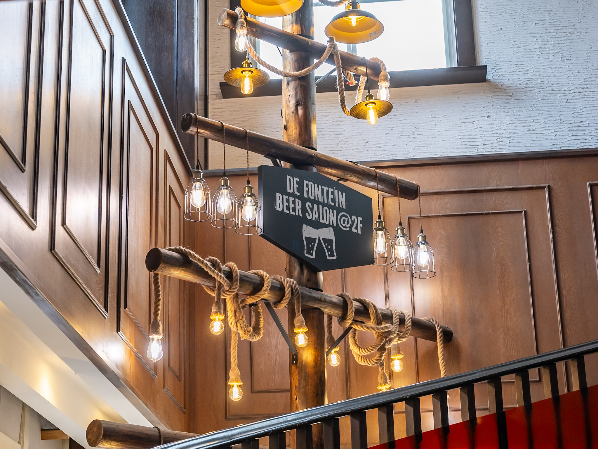 DE FONTEIN BEER SALON@2Fと書かれた階段上の看板