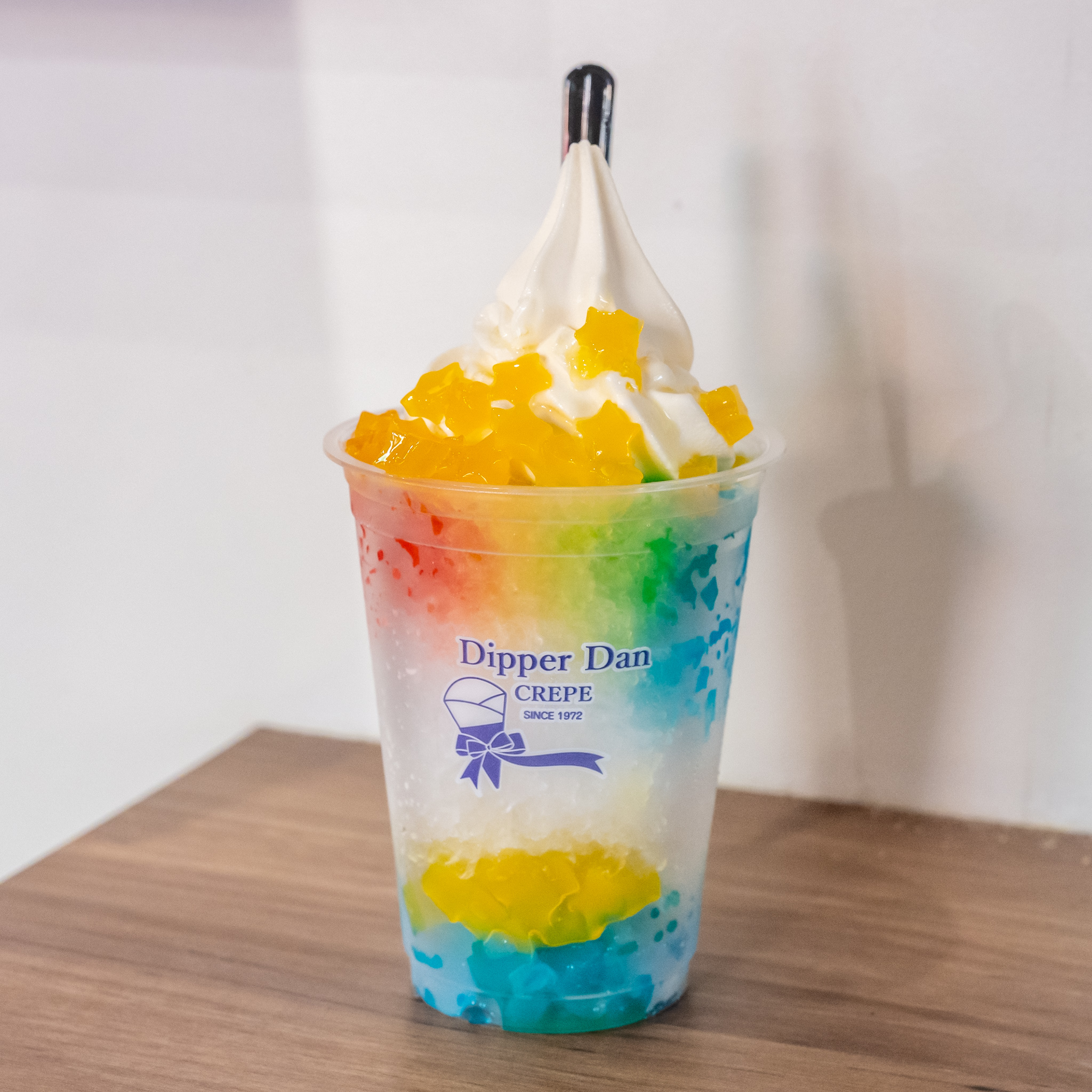 虹色の氷にソフトクリームと星型ナタデココをのせたニジイロ氷