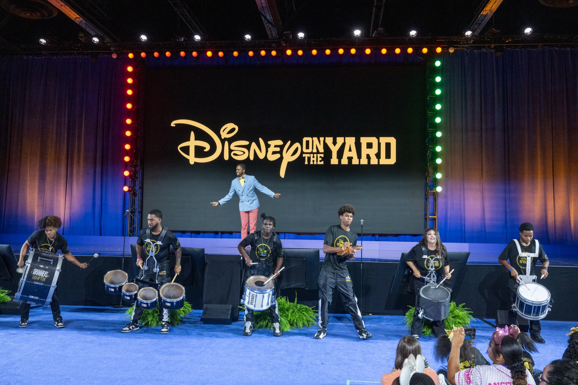 ステージ背面に掲げられた「Disney on the Yard」のロゴとドラムラインの奏者