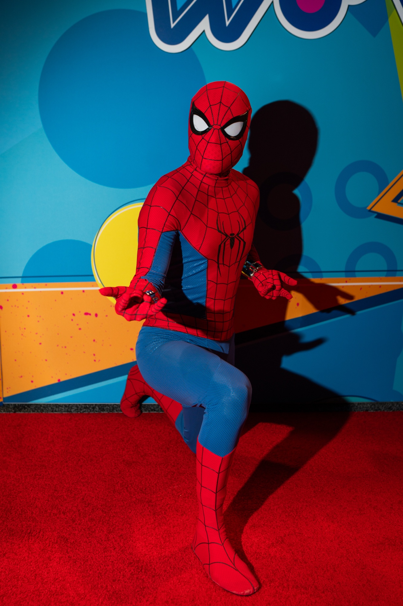 フォトブースの上に座るスパイダーマンのコスプレイヤー