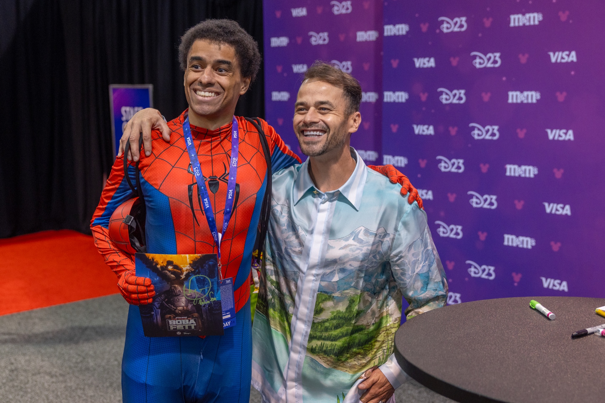 スパイダーマンの衣装の来場者と写真に応じるダニエル・ローガン