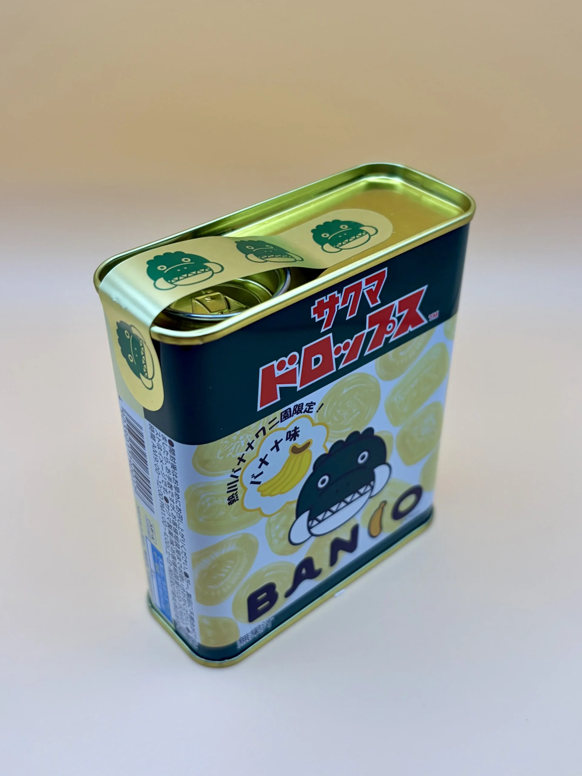 斜め上から見た熱川バナナワニ園 バナナドロップスの缶と開封用の帯