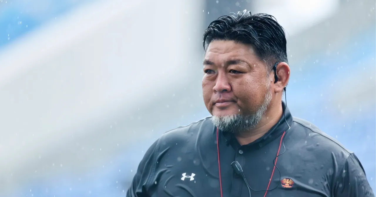 雨天のグラウンドに立つ相馬監督