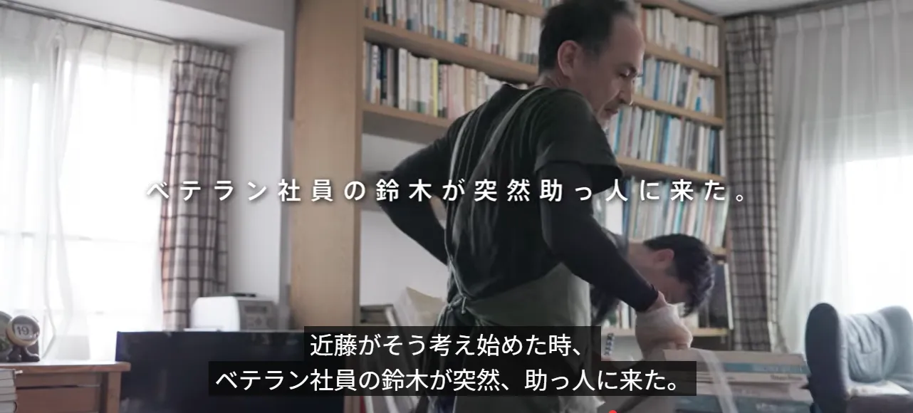 本棚の前で協力するベテラン社員と若手スタッフ