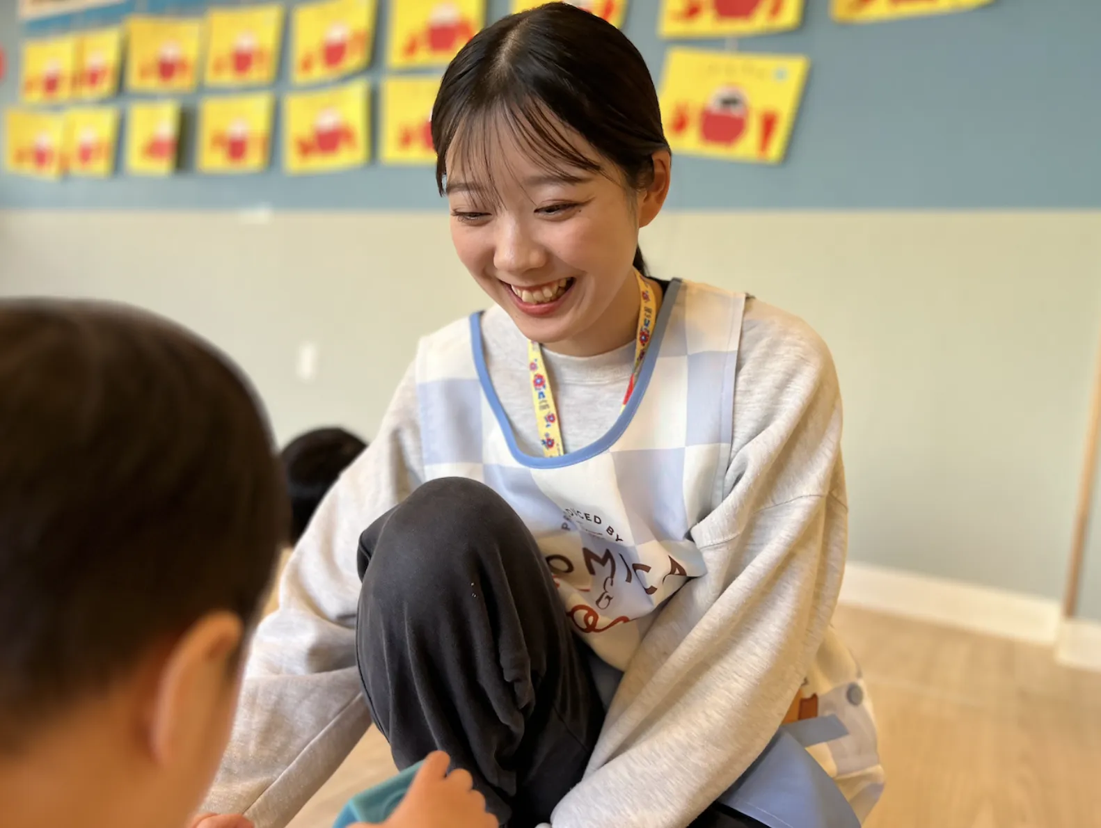 保育士が笑顔で園児に語りかける様子