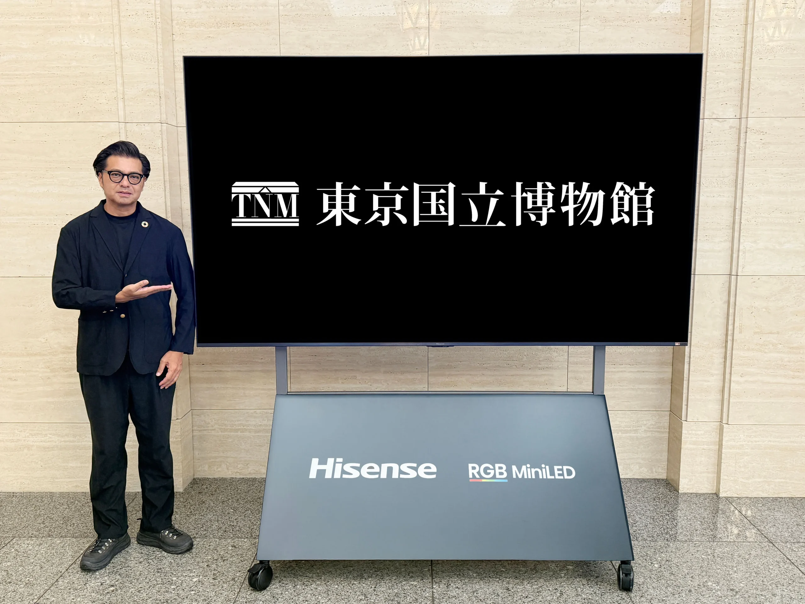 「100UXS」の大画面と男性の対比