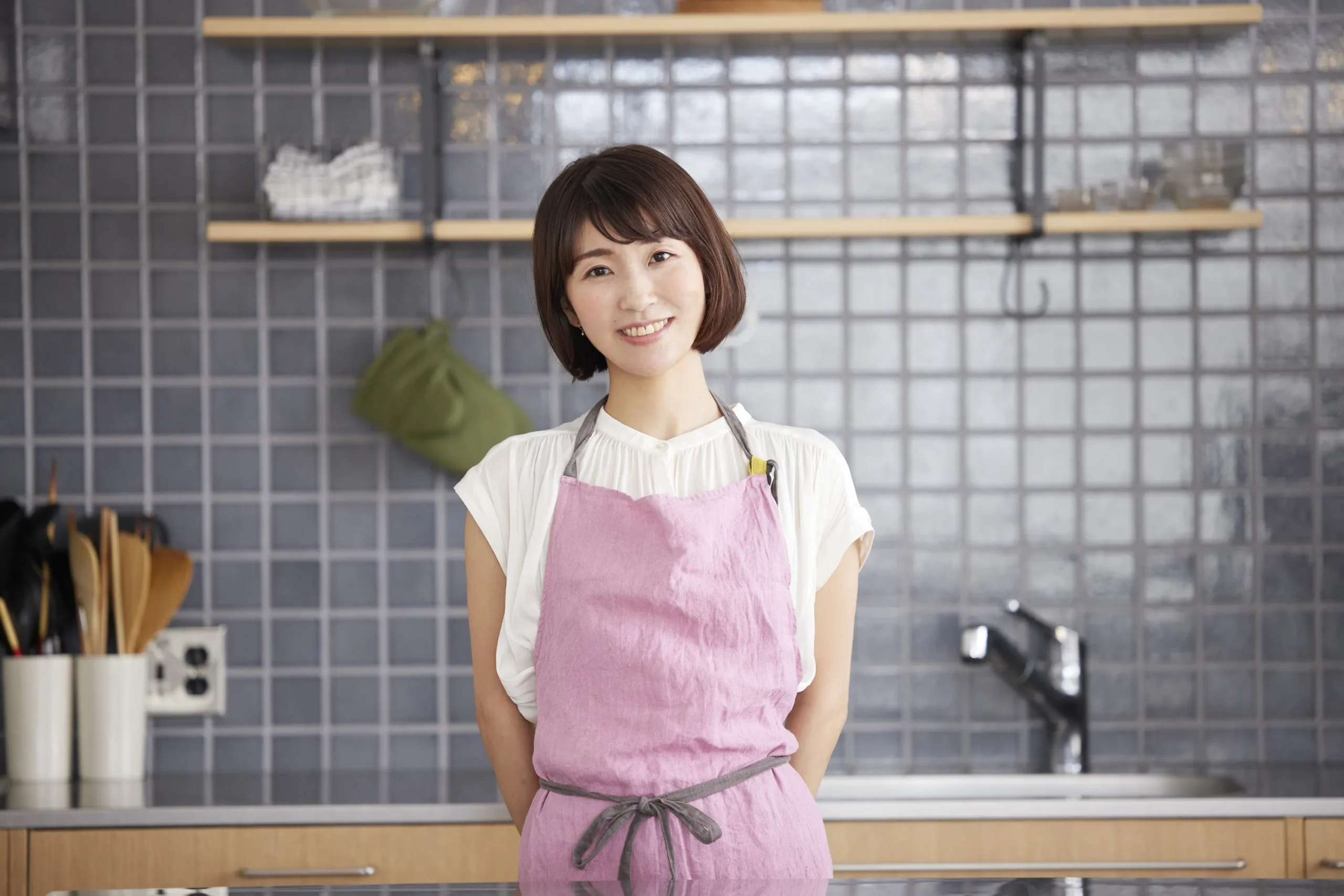 エプロン姿でキッチンに立つ女性