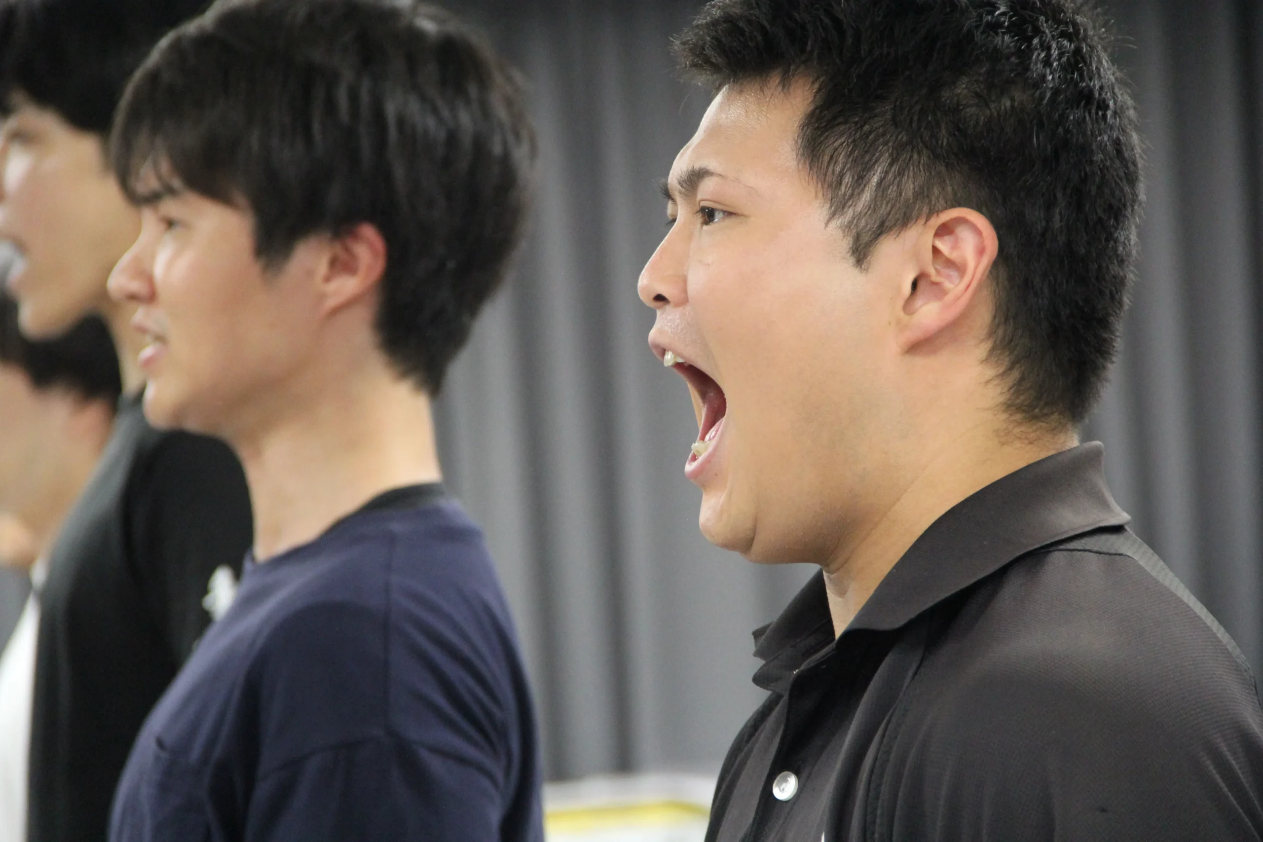 稽古場で声を合わせる男性出演者たち