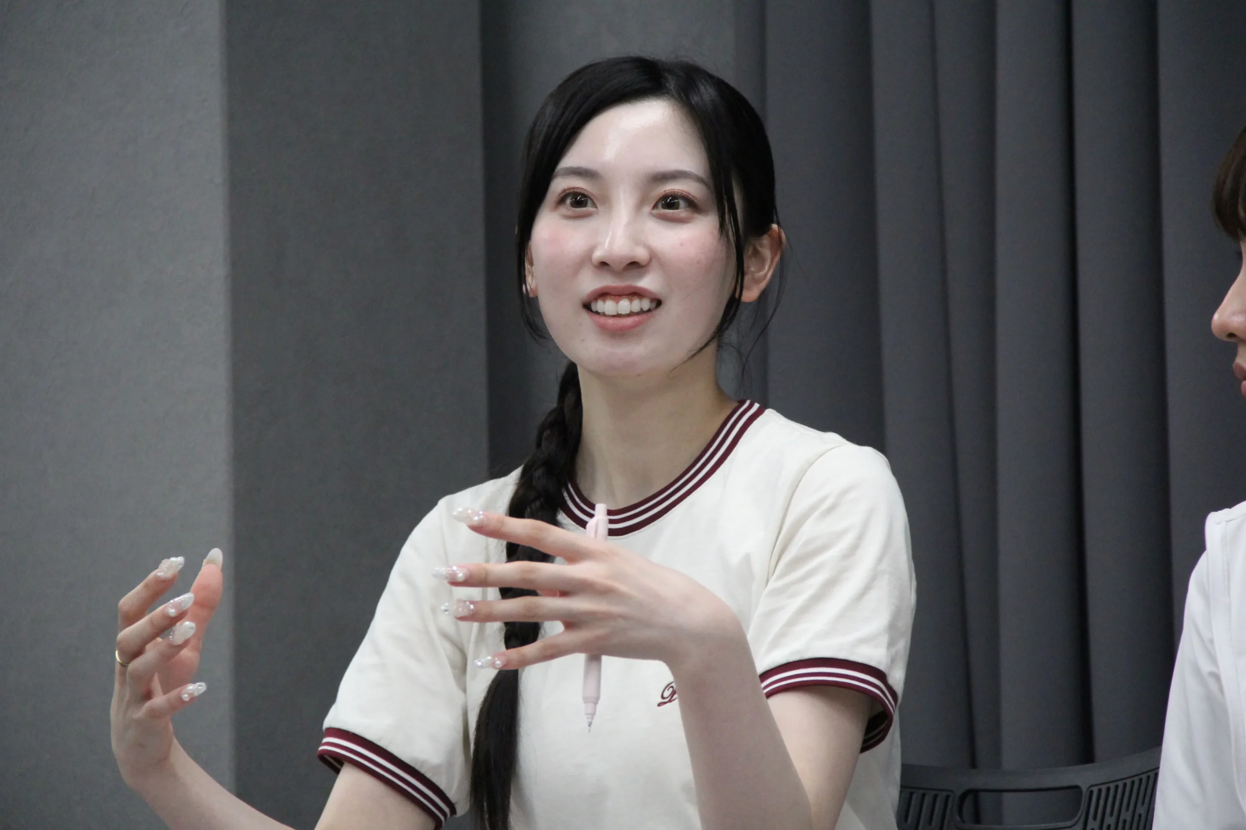 稽古場で身振りを交えて話す女性出演者