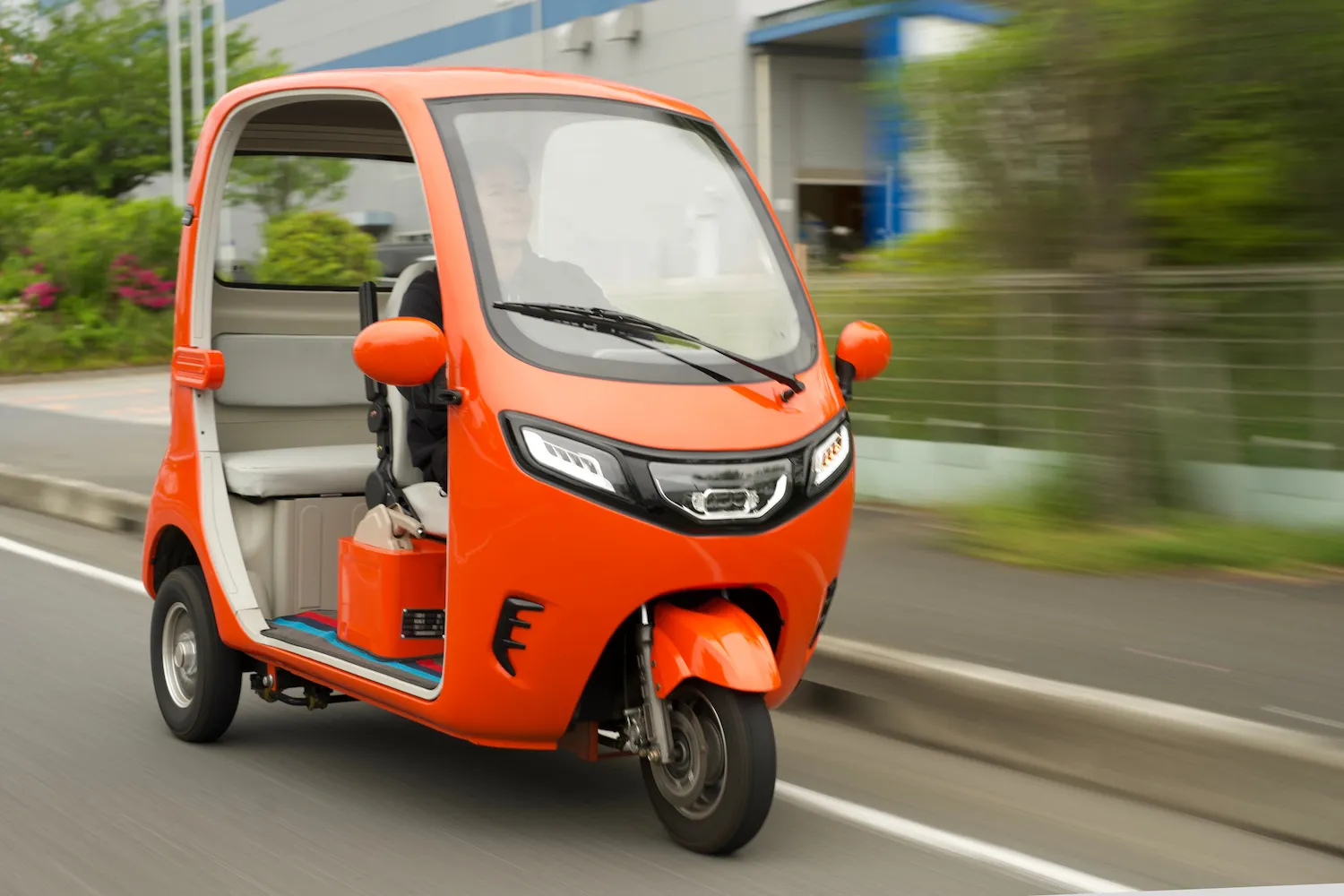 オレンジ色の「GOAT180」を運転する男性の走行シーン