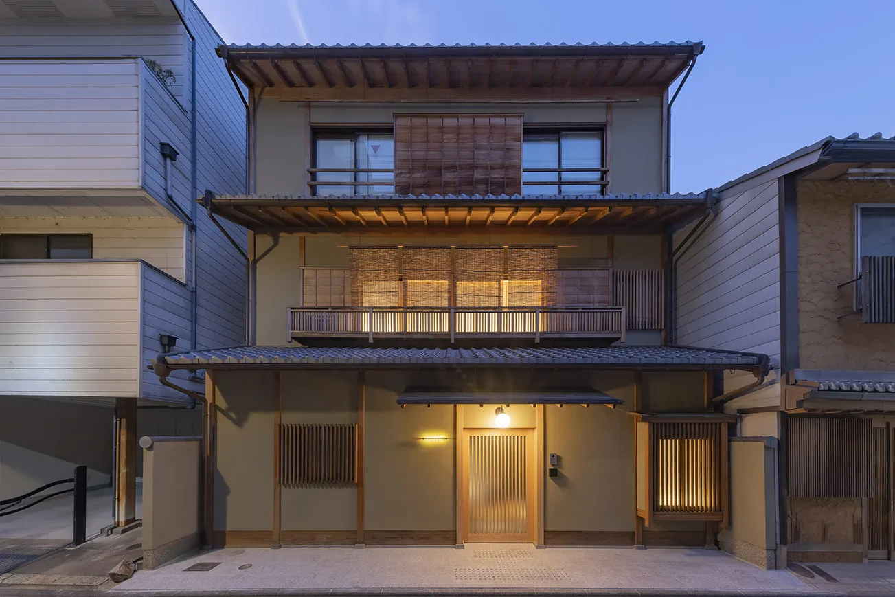 夕暮れに灯る新築の京町家風建物の外観
