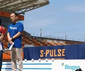 Biogenロゴ入りシャツ姿で表彰台に立つ大会関係者