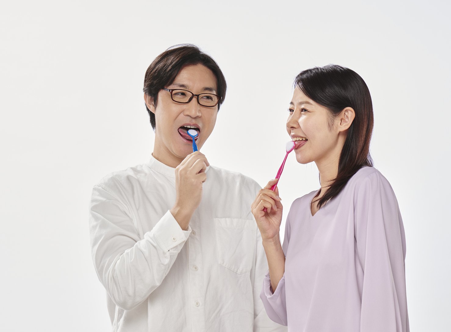 舌ブラシで舌をケアする男女