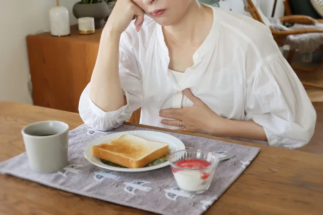 トーストを前に食欲がわかない様子の女性