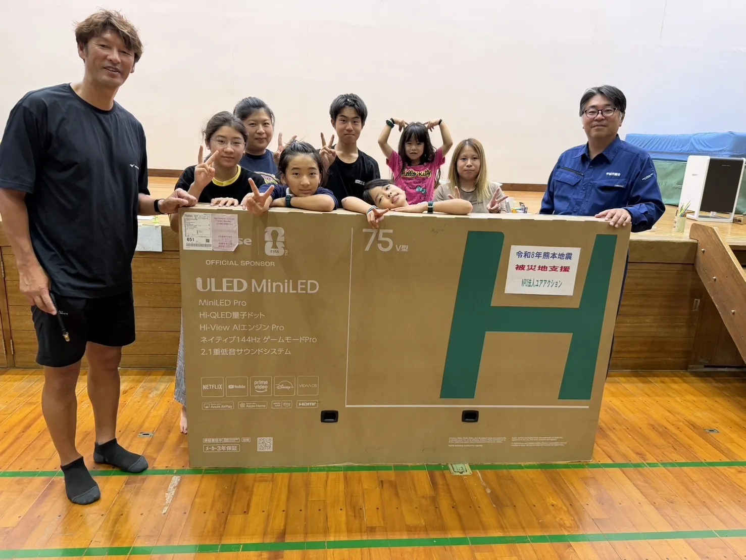 体育館で地域の子どもたちと「75U7S」を囲む関係者