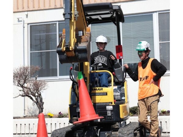 指導を受けながら、落ち着いて小型の重機を操作する参加者