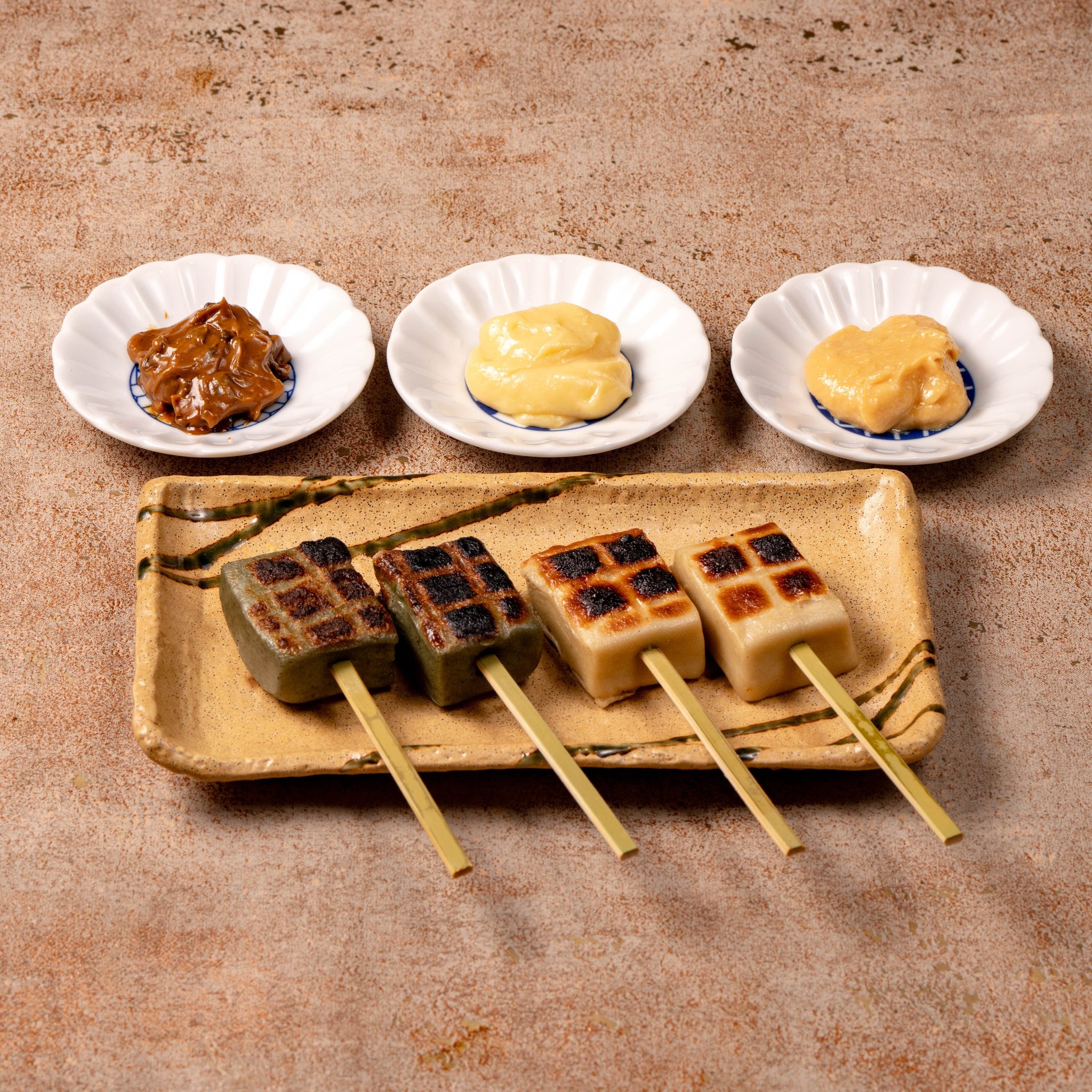 格子状の焼き目がついた生麩の田楽串と味噌だれ3種