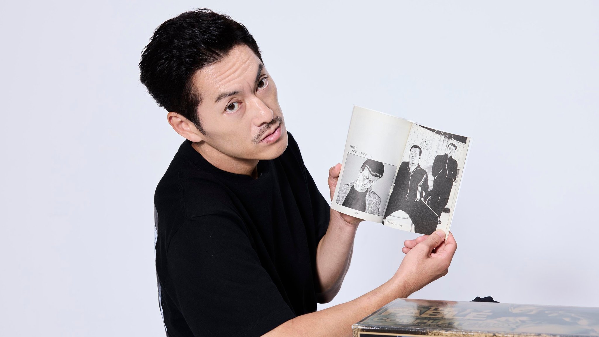 般若さんが見開きページを手にする様子