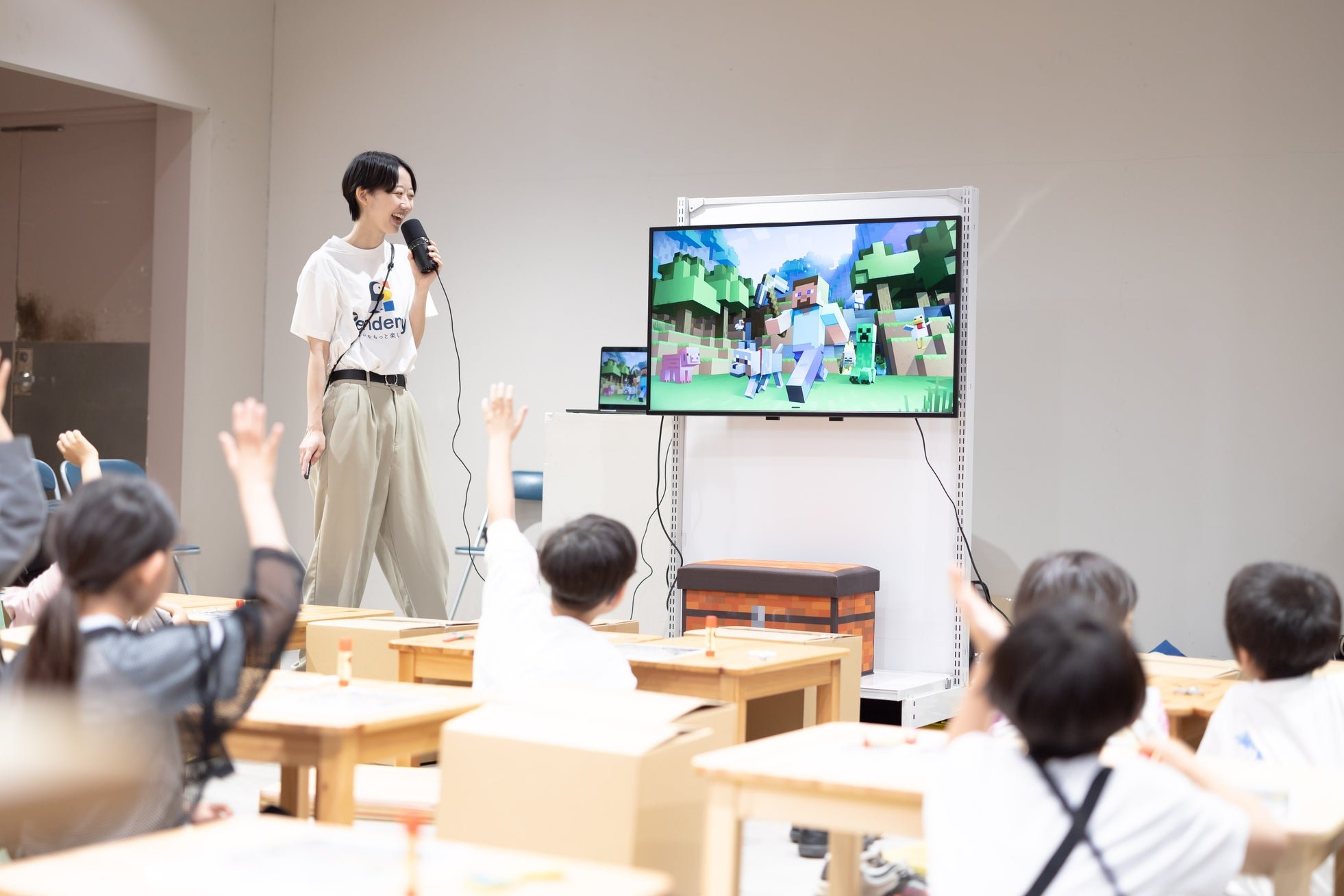 マインクラフトの画面を使って「元素」を解説するスタッフと挙手する参加者