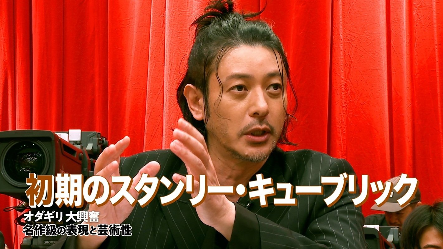 赤いカーテンを背景に語る出演者