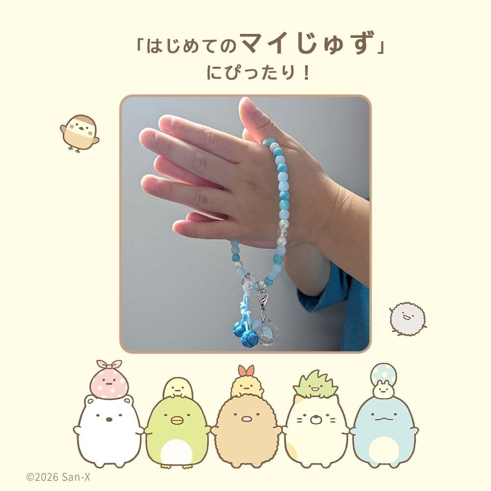 水色の数珠を手にはめて手を合わせる子ども