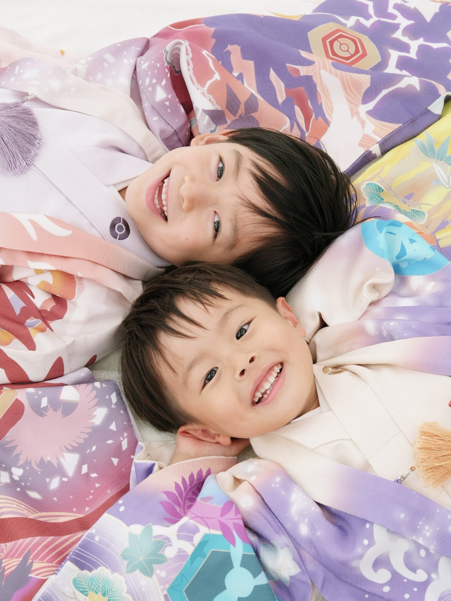 ポケモン和装を着た二人の子どもが頭を寄せ合う様子