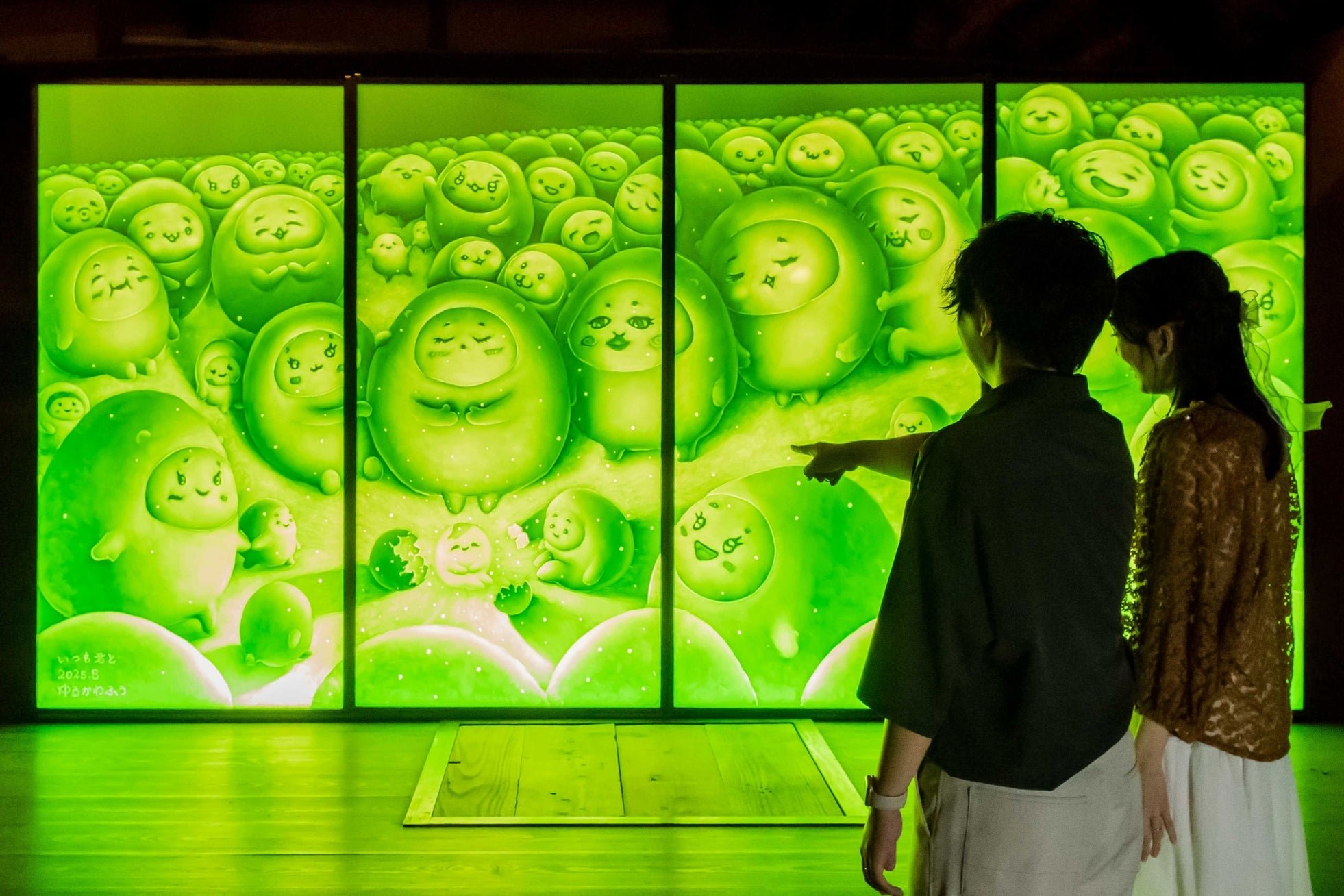 緑色にライトアップされた「光彫り」作品展のパネルアート