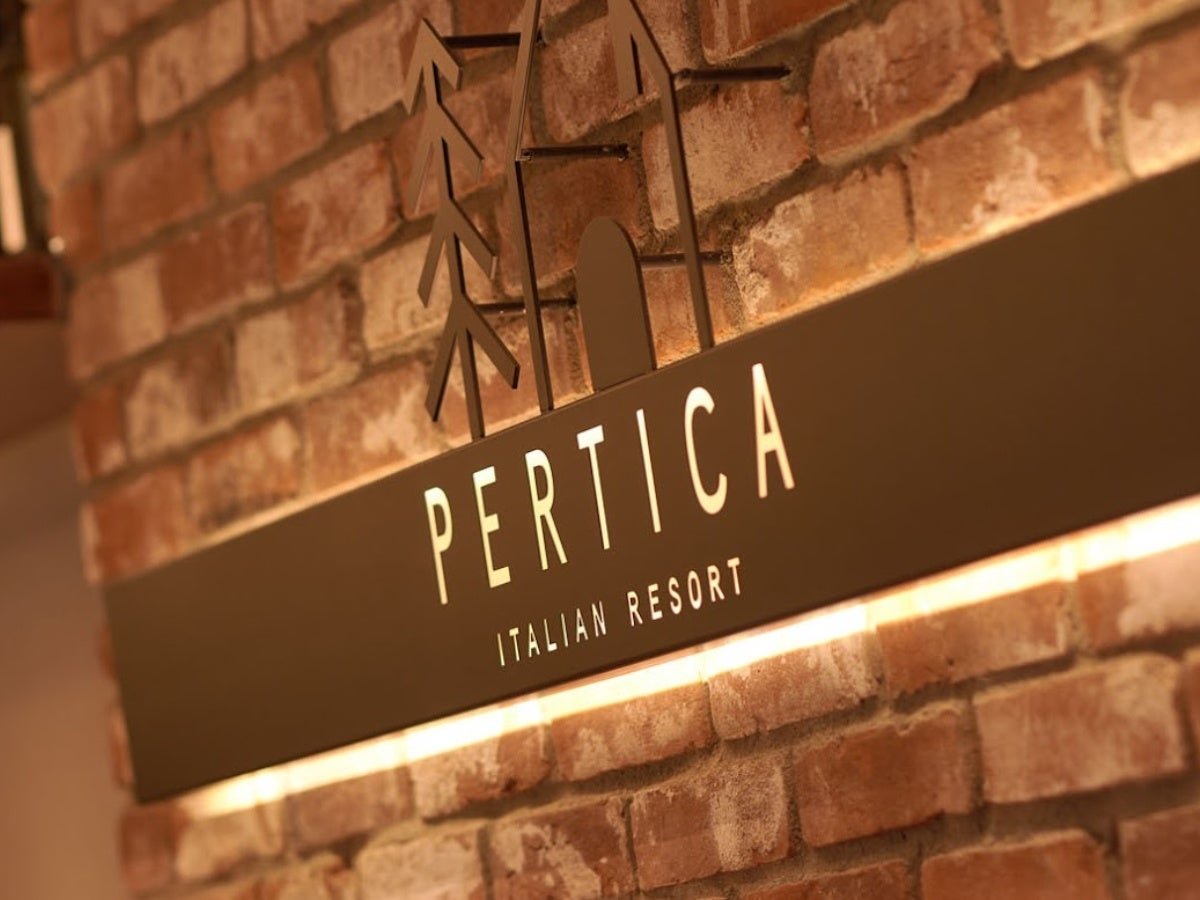 レンガ壁のPERTICA ITALIAN RESORT看板