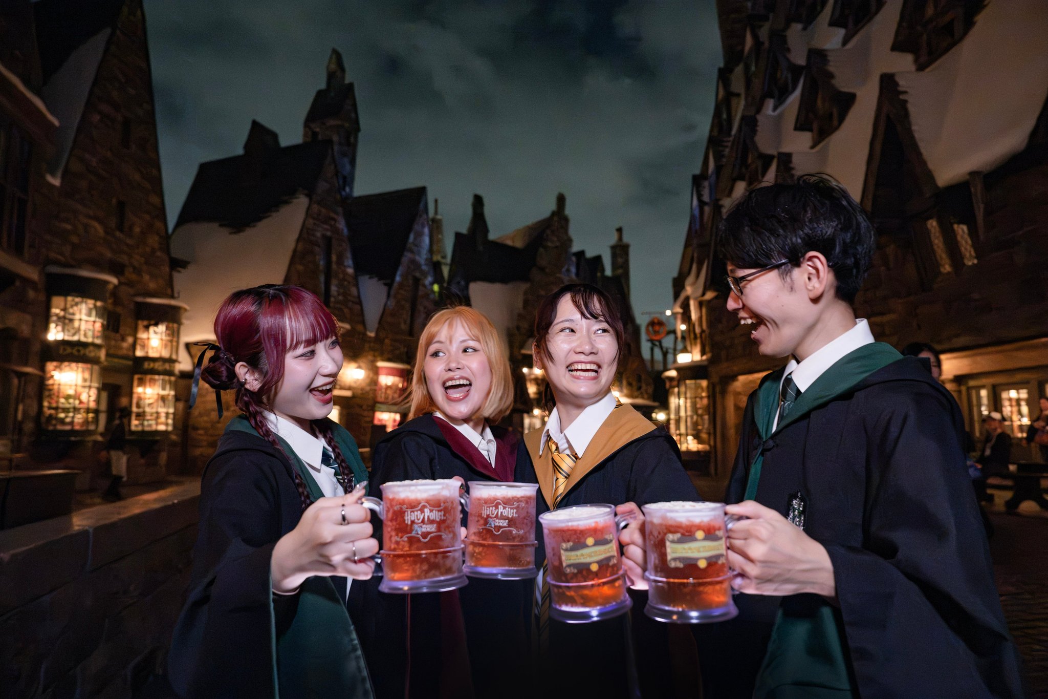 映画公開25周年記念マグカップでバタービールを楽しむ参加者たち