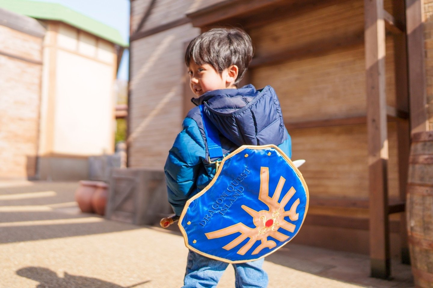 「ドラゴンクエスト アイランド」のシールド型グッズを身につけた来場者