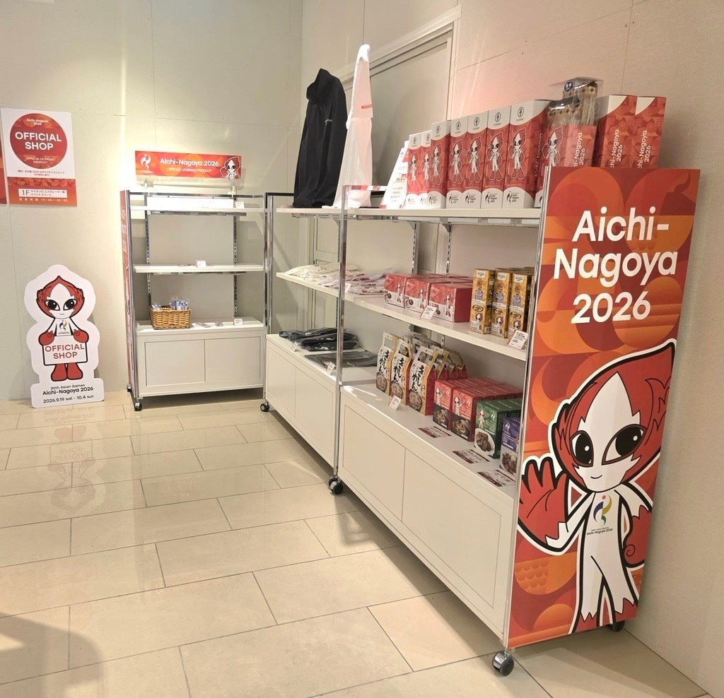 赤い大会マスコットの案内看板と公式ライセンスグッズが並ぶ、名古屋栄三越1階の売場