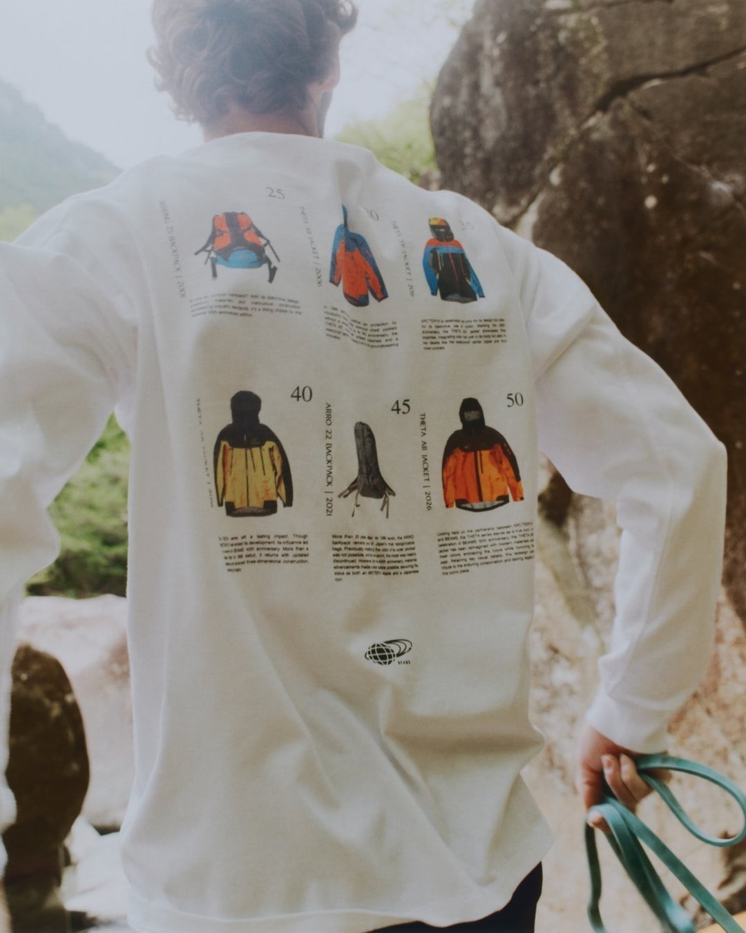 背中にグラフィックプリントを施したロングスリーブTシャツを着用した後ろ姿