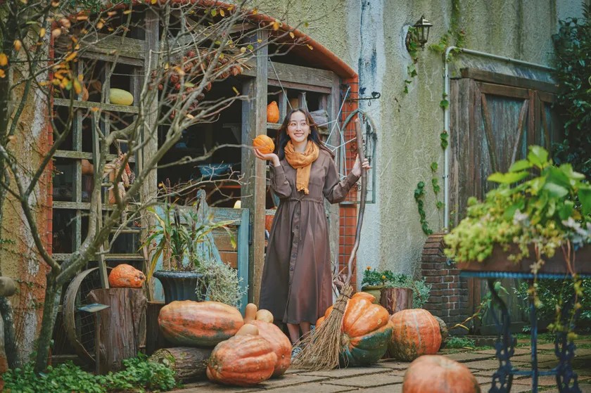 かぼちゃを手にした女性とハロウィン装飾