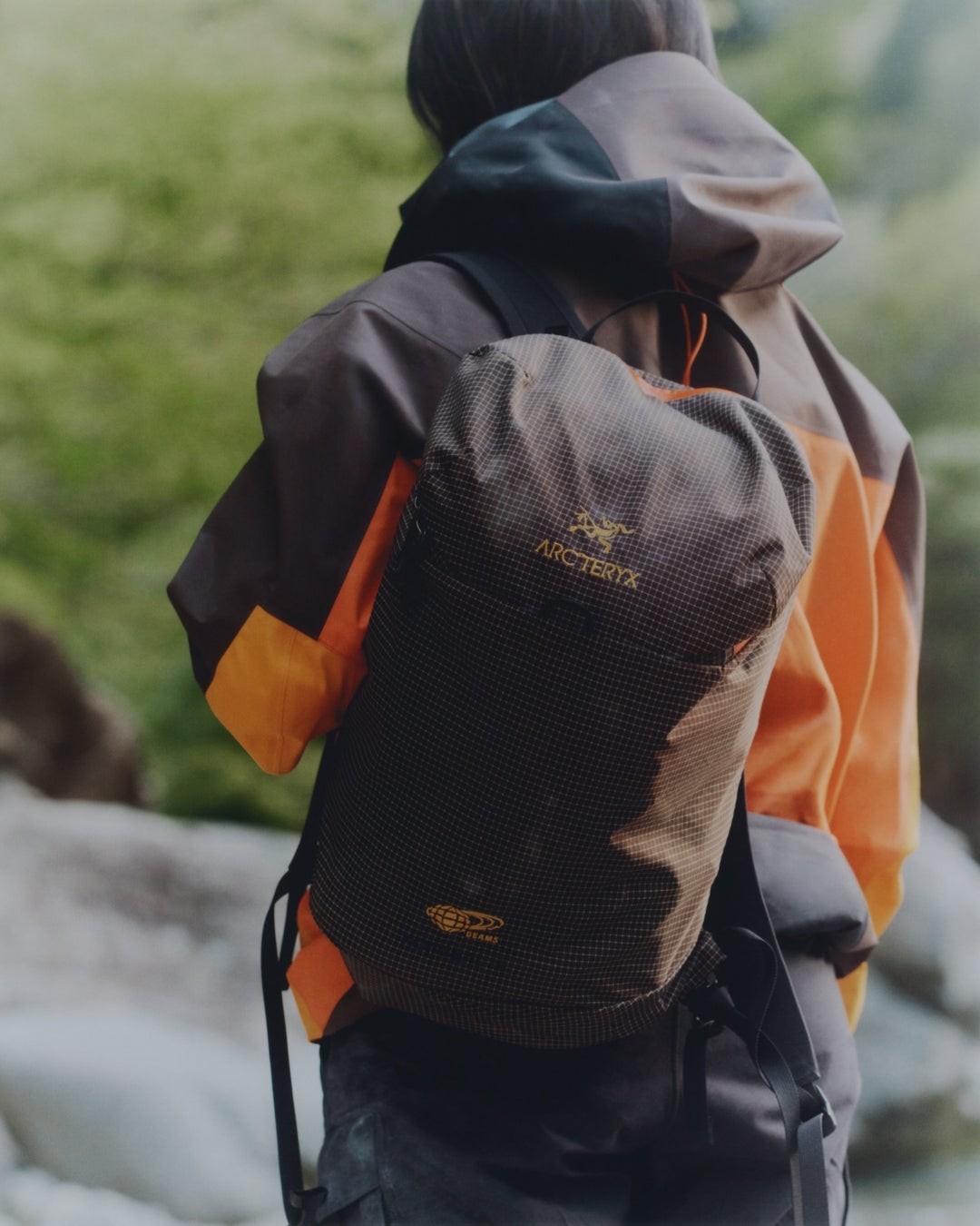 バックパックを背負って歩く人物の後ろ姿