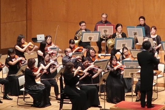 横浜交響楽団の紹介写真。弦楽器や管楽器の奏者が並ぶステージ