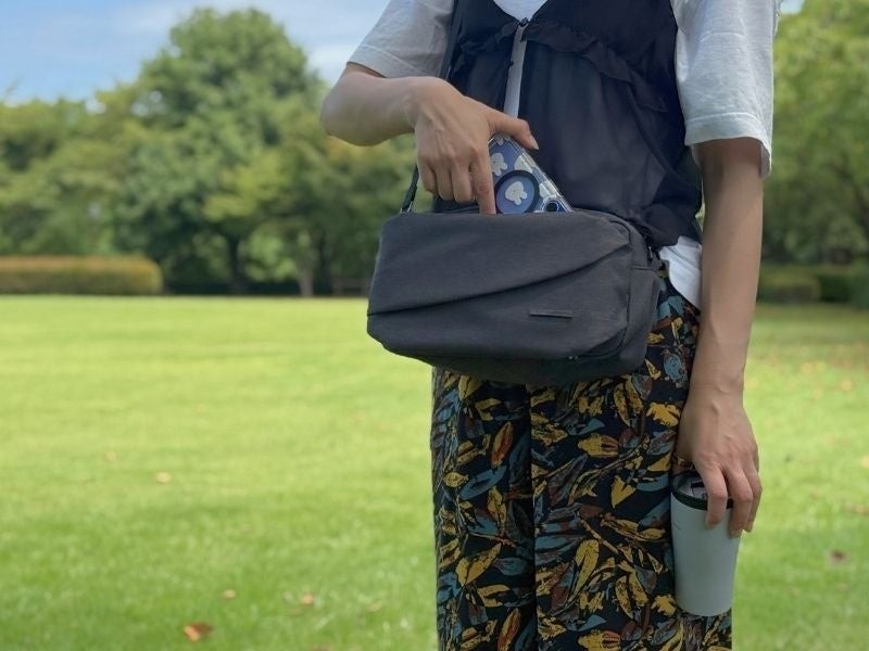 QUICK PACK shoulderのスマポッケからスマートフォンを取り出す様子