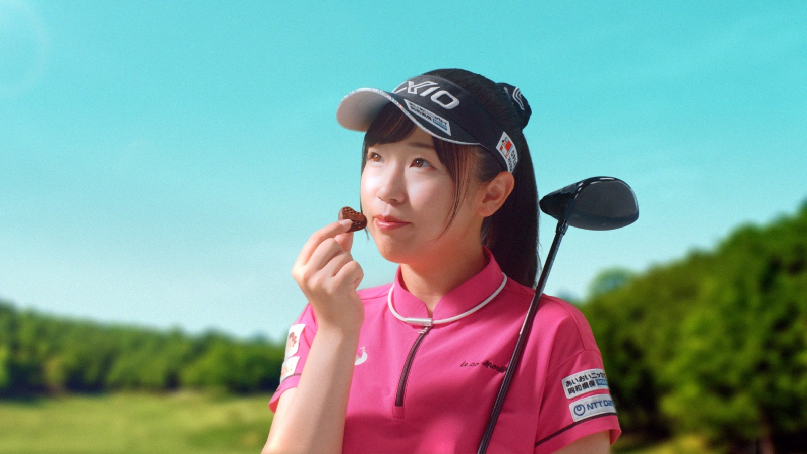 ゴルフウェア姿の菅沼菜々選手がハートチョコレートを口にするCMシーン