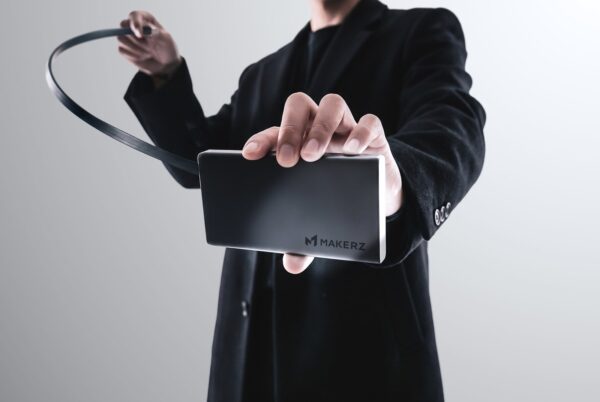 巻取り式ケーブルを引き出した「SOLIDZ Power Bank Model IT」を持つ手元