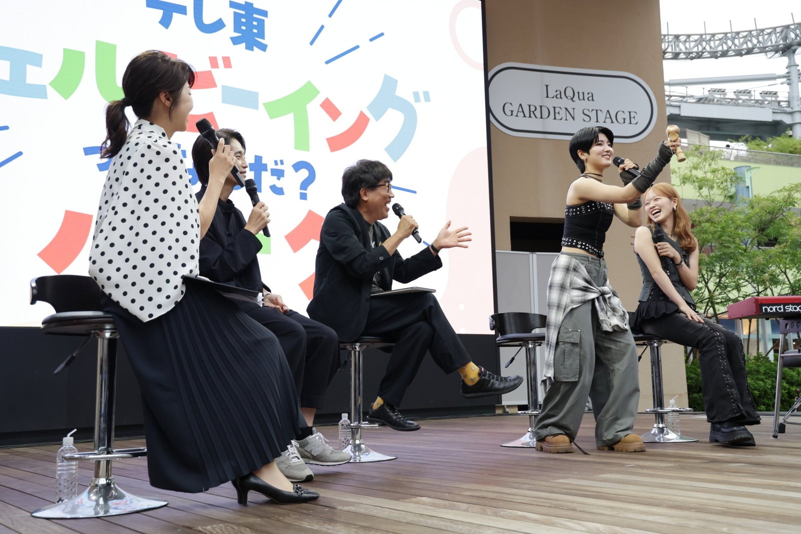 けん玉を掲げる出演者とステージのトーク風景