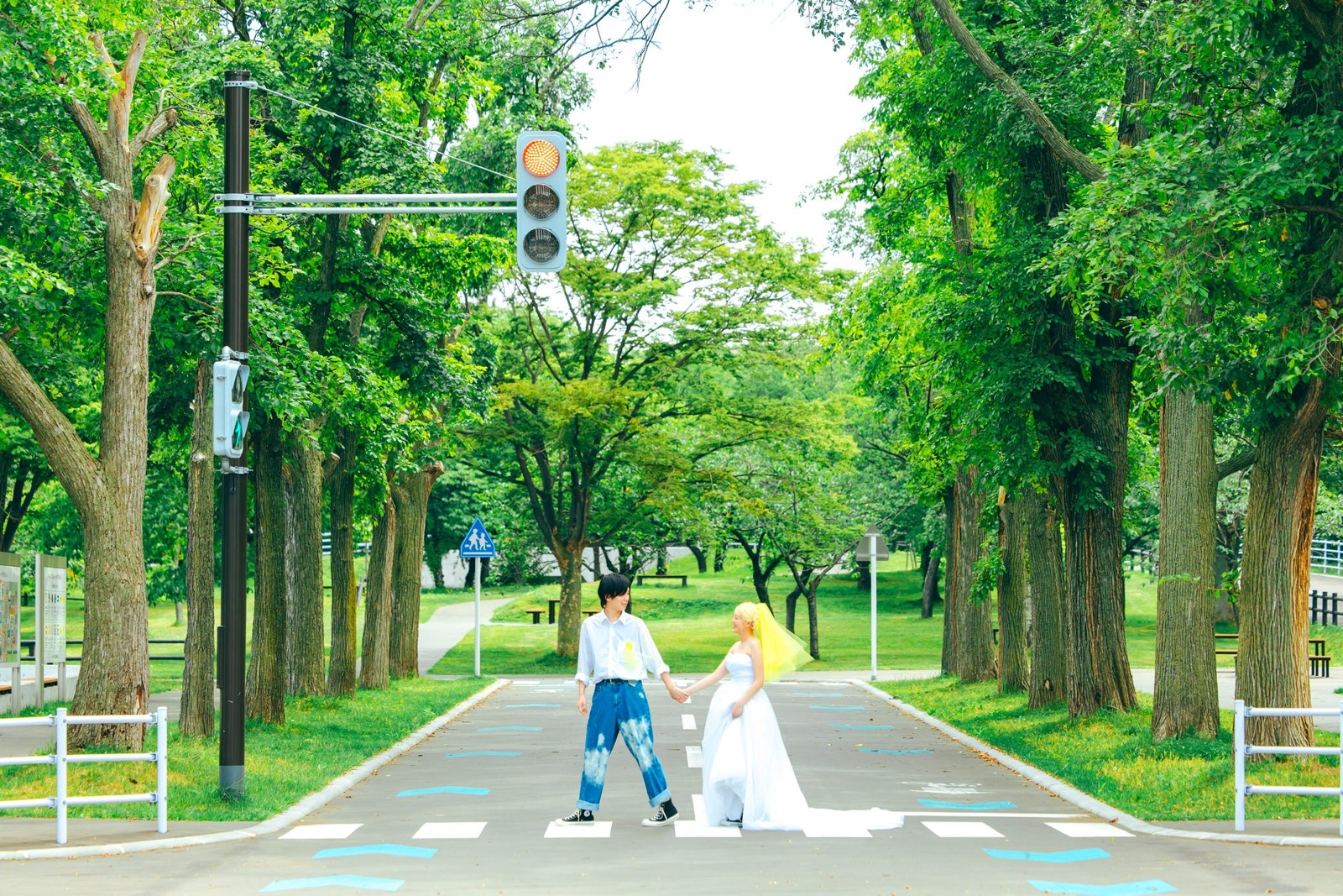 農試公園内の横断歩道を手をつないで歩く新郎新婦