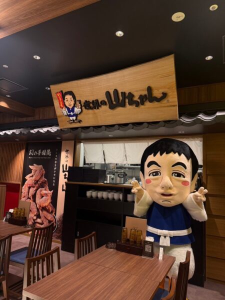 世界の山ちゃん丸八別邸の看板とマスコットキャラクター