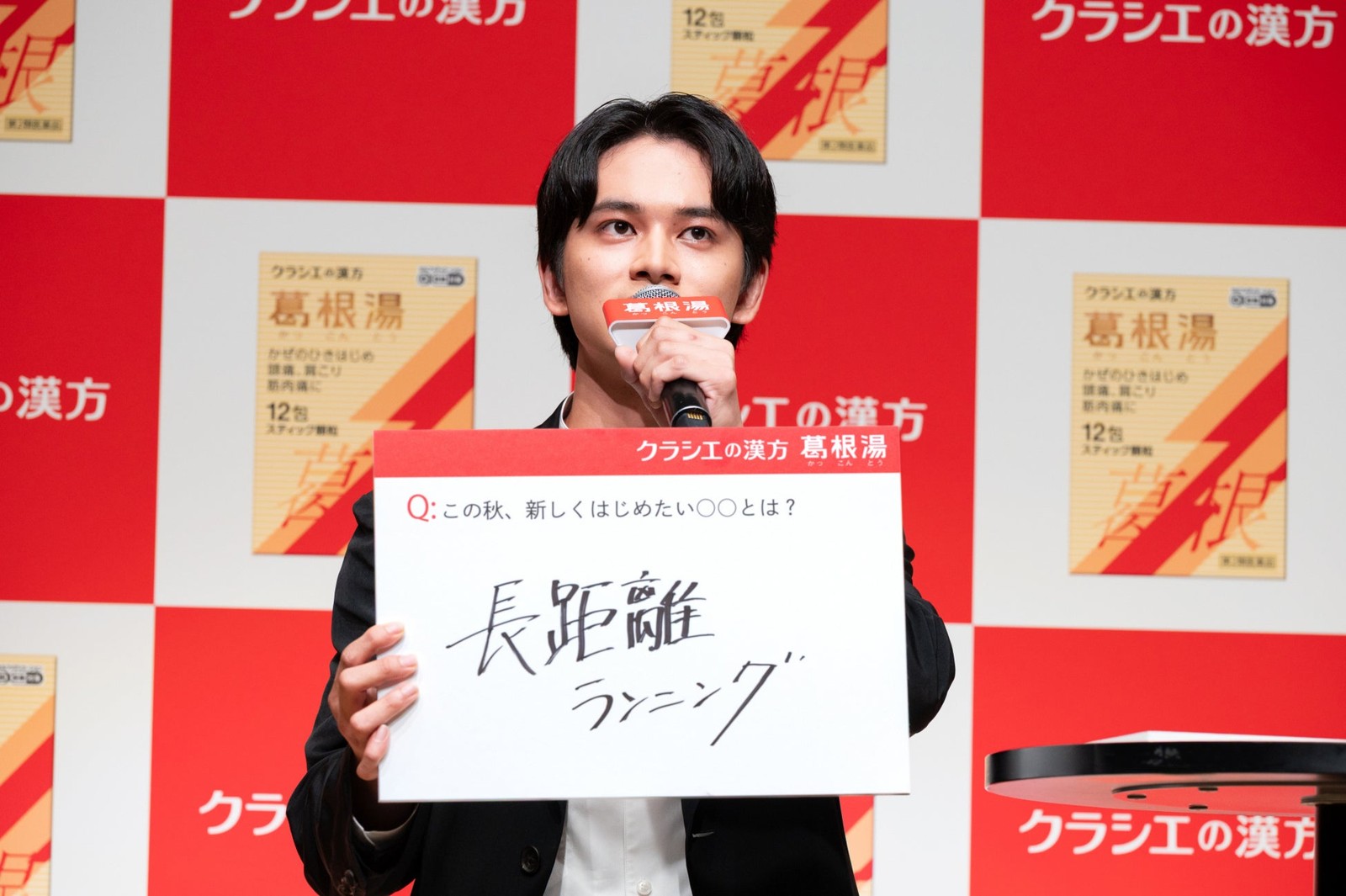 「長距離ランニング」と書かれたフリップを持つ北村匠海さん