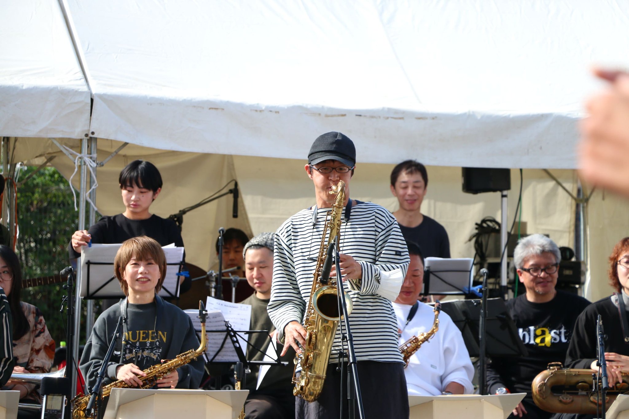 テント下でサックスを演奏する奏者