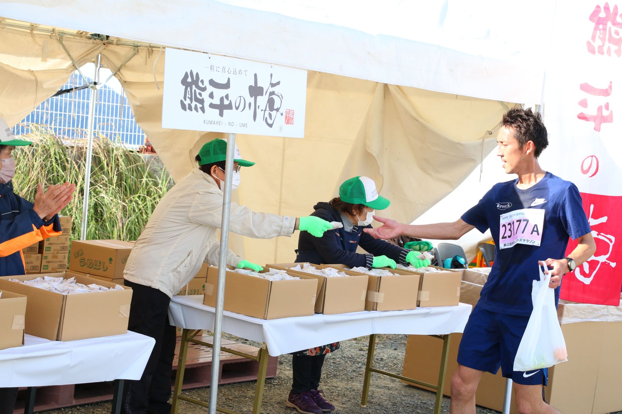 「熊平の梅」のテントで梅干しを受け取るランナー